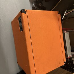 Kytarový kombozesilovač potažený oranžovým texturovaným vinylem s černými plastovými rohy. Na boční straně je umístěn černý ovládací panel s přepínač…