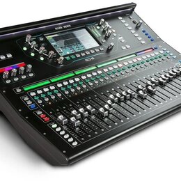 Černý digitální mixážní pult s kovovým povrchem a množství posuvníků, tlačítek a ovladačů. V horní části je umístěn displej s nápisy ALLEN & HEATH a…