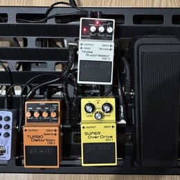 Černý pedálboard s několika efektovými pedály. Jsou zde pedály Electro-Harmonix NEO CLONE, MODER, BOSS TURBO Distortion DS-2, BOSS SUPER OverDrive SD…