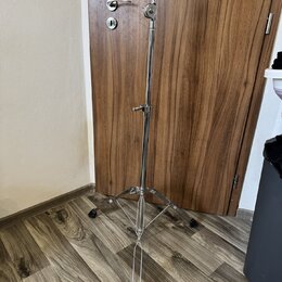Stříbrný kovový mikrofonní stojan s trojnožkou a rozkládacím mechanismem. Stojan má v horní části držák pro mikrofon a uprostřed regulační šroub. Pov…