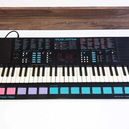 Černý elektronický klávesový nástroj s bílými a černými klávesami. Na horním panelu je nápis Music STATION, digitální displej zobrazující hodnoty 0.0…