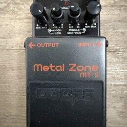 Černý kytarový efekt pedál s nápisy Metal Zone a mt-2 v oranžové barvě a vyraženým logem BOSS. Na pravé straně jsou čtyři ovládací knoflíky a nápisy…