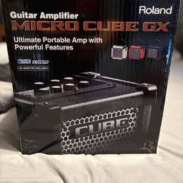 Kartonová krabice s kytarovým zesilovačem. Na povrchu je nápis Roland a model MICRO CUBE GX s textem Ultimate Portable Amp with Powerful Features. Js…