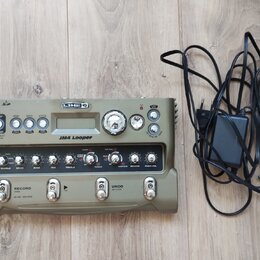 Zelený looper Line 6 JM4 Looper s kovovým šasi a ovládacími prvky. Na předním panelu jsou čtyři spínače, displej a řada otočných potenciometrů s nápi…