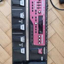 Černý loop station Boss RC-300 s růžovými ovládacími panely. Zařízení obsahuje tři sekce s nápisy TRACK 1, TRACK 2 a TRACK 3, každá vybavená dvěma pe…