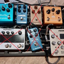 Na černém pedalboardu je umístěno šest efektových pedálů. V horní řadě jsou zleva modrý pedal s nápisy „blueSky“ a „strymon“, modrý pedal s nápisy „F…