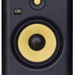 Černý studiový monitor s žlutým membránovým reproduktorem a žlutým výškáčem. V horní levé části je umístěno logo KRK SYSTEMS. Povrch je v matném prov…
