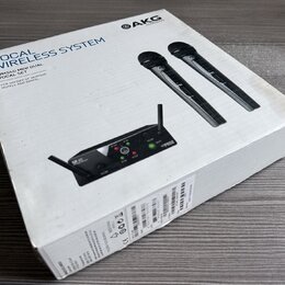 Bílá kartonová krabice s nápisy VOCAL WIRELESS SYSTEM a WMS40 MINI DUAL VOCAL SET. V horní části je logo AKG HARMAN, na obrázku jsou dva černé bezdrá…