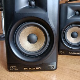 Dva černé studiové monitory s Kevlarovými membránami v béžové barvě. Na spodní hraně je uveden nápis M-AUDIO a vlevo označení SPEAKER MODES s možnost…