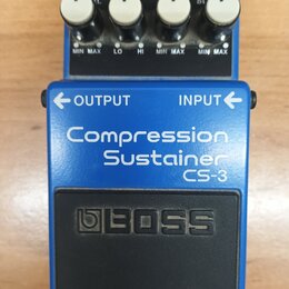 Modrý efekt pedál s nápisy Compression Sustainer a CS-3. Na horní části jsou čtyři bílé otočné oválkové knoflíky s popisky MIN MAX, LO, HI a CHECK s…