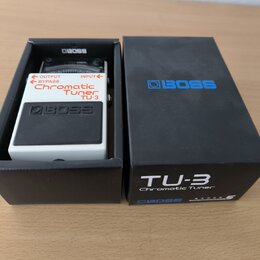 Bílá efektová pedál s černým ovládacím panelem v černé krabici. Na pedálu je nápis Chromatic Tuner TU-3 a logo BOSS, s označením OUTPUT, BYPASS a INP…