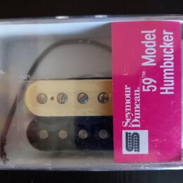 Průhledný plastový obal obsahuje dva humbuckery, jeden v krémové a druhý v černé barvě. Na růžovém štítku je uveden nápis Seymour Duncan 59 Model Hum…