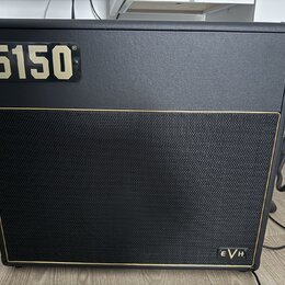 Černý kytarový kombozesilovač s texturovaným povrchem a černou textilní maskou reproduktoru ohraničenou zlatou linkou. V levém horním rohu je umístěn…