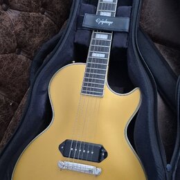 Zlatá elektrická kytara s jedním humbuckerem v pozici kobylky, umístěná v černém obalu. Na hlavě nástroje je bílé logo Epiphone a nápis Les Paul Spec…