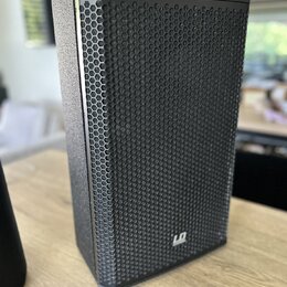 Černý reproduktor s kovovou mřížkou včelí struktury. V pravém dolním rohu je bílé logo LD Systems. Povrch skříně má jemnou texturu a vypadá být v dob…