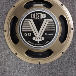 Kruhový reproduktor se zlatým kovovým rámem. Na středovém krytu je černobílý nápis CELESTION, velký symbol V a texty G12, 70-watt, TYPE a CELESTION I…