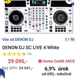 Bílý DJ kontrolér s černými jog-wheels a ovládacími prvky. Na horní části jsou nápisy DENON DJ a SC LIVE 4. Za přístrojem je umístěn bílý monitor zob…