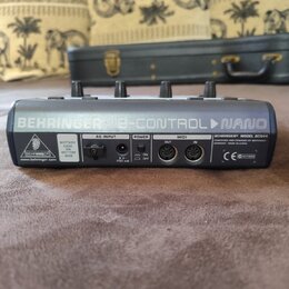 Zadní strana černého MIDI kontroléru s nápisem BEHRINGER B-CONTROL NANO. Na zařízení jsou vidět konektory AC INPUT, POWER a MIDI (OUT, IN), přepínač…