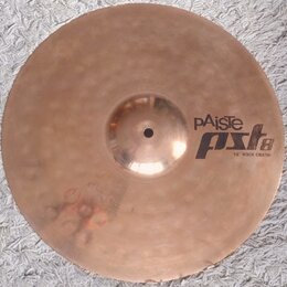 Kruhový mosazný činel s viditelným kovánívým povrchem. Na pravé straně je černý nápis pAiste a pod ním model PST 8 s doplňkem 16" ROCK CRASH. Povrch…