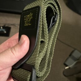 Zvolněný kytarový popruh v olivově zelené barvě z textního materiálu. Na černé kožené části je žlutý nápis ERNIE BALL. Popruh vykazuje mírné známky p…