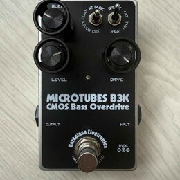 Černý efekt pedál s nápisy MICROTUBES B3K a CMOS Bass Overdrive. Na spodní části je logo Darkglass Electronics a označení napájení 9VDC. Pedál má dva…