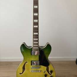 Polodupatá elektrická kytara s žlutozeleným přechodem barvy na těle a hnědým hmatníkem s blokovými vložkami. Nástroj má dva humbuckery, stříbrný most…