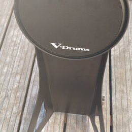 Černý elektronický bicí pad na stojanu. Na horní části je bílý nápis Roland a pod ním V-Drums. Povrch padu i stojanu je v dobrém stavu bez viditelnéh…