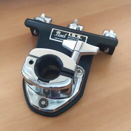 Černý kovový držák s chromovanými prvky a utahovacím šroubem. Na bílém štítku je nápis Pearl I.S.S. INTEGRATED SUSPENSION SYSTEM a drobný text made i…