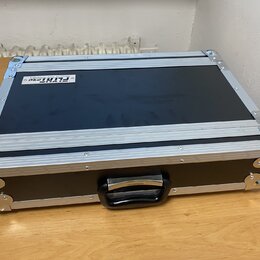 Černý transportní kufr s hliníkovými hranami a kovovými rohy. Na horní části je bílá nálepka s nápisy „FlyRig 30“ a „PORTABLE MULTI-EFFECT PROCESSOR“…
