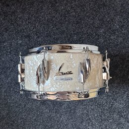 Bílá buben s perleťovým povrchem a chromovanými obručemi. Na horním obruči je nápis SONOR Vintage Superphonic a na korpusu se nachází logo Sonor s ná…