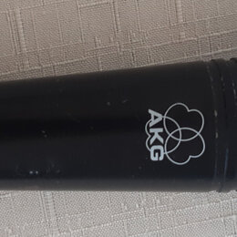 Černý dynamický mikrofon s kovovou síťkou a zeleným kroužkem. Na těle je bílé logo AKG a nápis D 880, který se opakuje i v zeleném poli u spodní část…