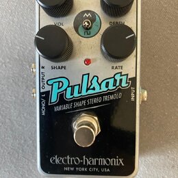 Stompbox efekt s kovovým stříbrným šasi a černým spodním panelem. Na horní části jsou čtyři černé oválné ovladače s popisky VOL, DEPTH, SHAPE a RATE.…
