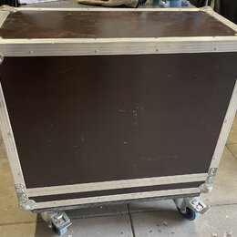 Hnědý transportní kufr s hliníkovými hranami a rohy. Spodní část je vybavena čtyřmi kolečky. Povrch hnědého materiálu vykazuje drobné škrábance a opo…