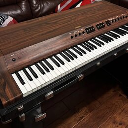 Digitální piano v dřevěném korpusu s tmavým povrchem imitujícím masiv. Na horní liště je nápis AHAMAN a několik ovládacích tlačítek s popisky. Kláves…