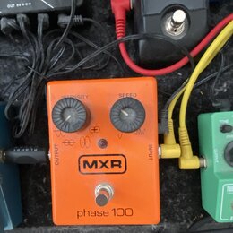 Kytarový efekt pedál oranžové barvy s nápisy MXR a phase 100. Na horní straně jsou dva černé oválové knoflíky s popisky INTENSITY a SPEED. V dolní čá…