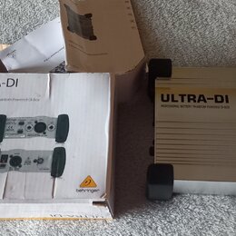 Na fotografii je stříbrná DI box s černými gumovými nožičkami a doprovodná kartonová krabice. Na zařízení i na krabici je uveden název ULTRA-DI a mod…