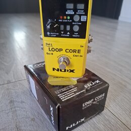 Žlutý loop pedal NUX LOOP CORE umístěný na své originální krabici. Zařízení má černý ovládací panel s nápisy USB, DC 9V, SAVE DELETE, STOP MODES a RH…