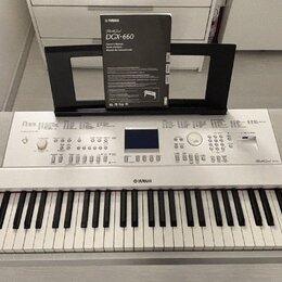Bílá digitální klaviatura značky YAMAHA, model DGX-660. Nástroj má v horní části ovládací panel s displejem, tlačítky a knoflíky, vpravo je nápis Dig…