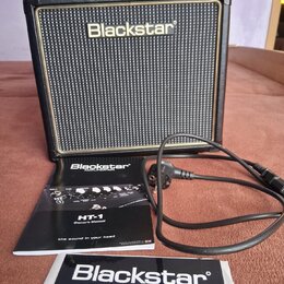 Černý kytarový kombozesilovač s texturovaným povrchem a zlatým lemem kolem mřížky. Na přední straně je bílý nápis Blackstar. Před zesilovačem leží už…