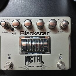 Bílá efektová pedál s nápisem Blackstar a modelem HT-METAL. Horní část obsahuje pět otočných potenciometrů s popisky GAIN 2, BASS, MIDDLE, TREBLE a L…