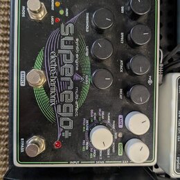 Černý multifunkční efektový pedál s nápisy SuperEgo, synth engine multieffect a elektro harmonix. Zařízení má pět černých otočných ovladačů, dva bílé…