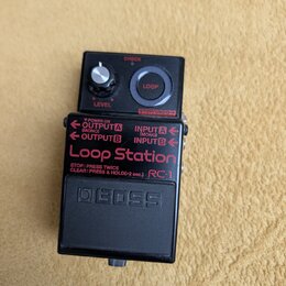 Černý efekt pedál značky BOSS s nápisem Loop Station a označením modelu RC-1. Horní panel obsahuje ovládací knob LEVEL, červené tlačítko LOOP a tlačí…
