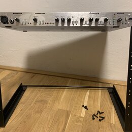 Stříbrný rackový procesor s černými ovládacími prvky umístěný na černém kovovém stojanu. Na zařízení jsou nápisy Focusrite, DISCRETE PREAMP, OPTICAL…