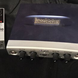 Na fotografii jsou dvě zařízení. Vlevo je bílá DI box s nápisy „behringer“, „ULTRA-DI DI20“ a „PROFESSIONAL ACTIVE 2-CH DI-BOX/SPLITTER“. Vpravo je s…