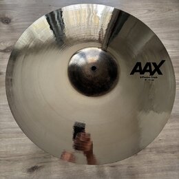 Kruhový činel z lesklého kovu s viditelným rýhováním. Na povrchu je černý nápis AAX a pod ním text X-Plosion Crash 18"/45 cm. Povrch je v dobrém stav…