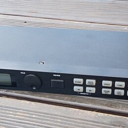 Černý rackový bubnový modul s nápisem ALESIS DM5 a doplňkem HIGH SAMPLE RATE 16 BIT DRUM MODULE. Zařízení má malý displej, jeden ovratový ovládací kn…