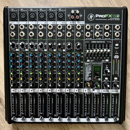 Černý 12kanálový mixážní pult s nápisem ProFX12 PROFESSIONAL EFFECTS MIXER. Zařízení obsahuje řadu vstupních kanálů s ovládacími knofíky, posuvníky a…