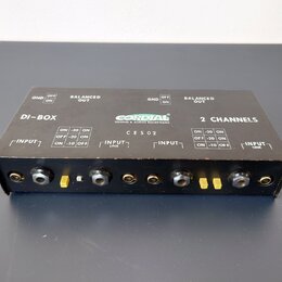 Černá DI-box s nápisy DI-BOX, 2 CHANNELS a logem CORDIAL SOUND & AUDIO EQUIPMENT. Na horní straně je označení CES02 a přepínače pro GND (OFF/ON), BAL…