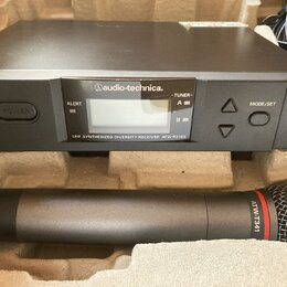 Černý bezdrátový přijímač s nápisem audio-technica. a označením UHF SYNTHESIZED DIVERSITY RECEIVER ATW-R3100. Obsahuje displej, tlačítka POWER a MODE…