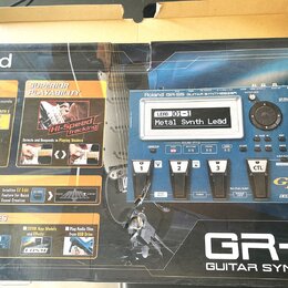 Fotografie znázorňuje krabici od kytarového syntetizátoru s nápisem Roland GR-55 GUITAR SYNTHESIZER. Na obalu je zobrazen modrý přístroj s displejem,…